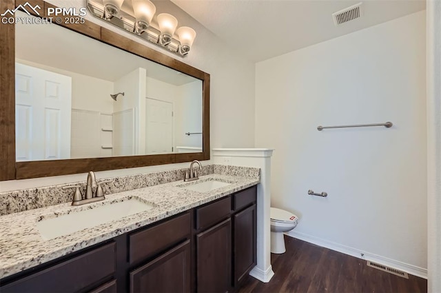 full bathroom featuring toilet, wood finished floors, a sink, and visible vents