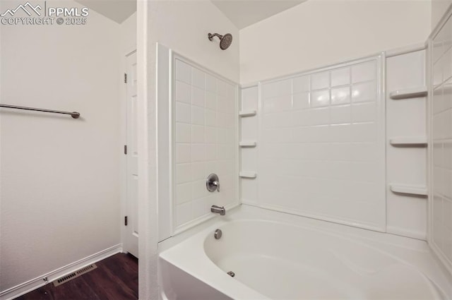 full bathroom with shower / bathing tub combination, wood finished floors, visible vents, and baseboards