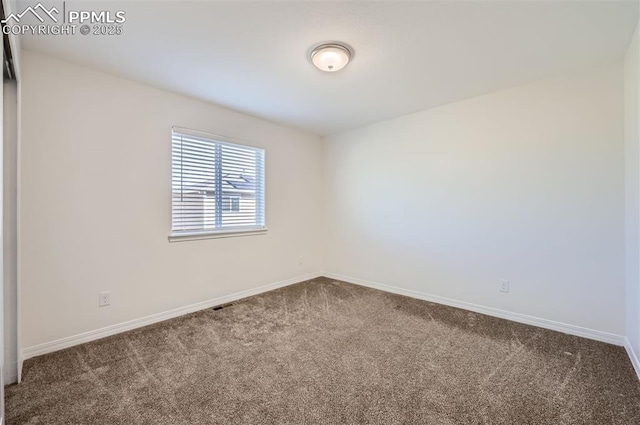 carpeted spare room with visible vents and baseboards