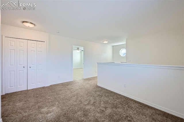 spare room featuring carpet and baseboards