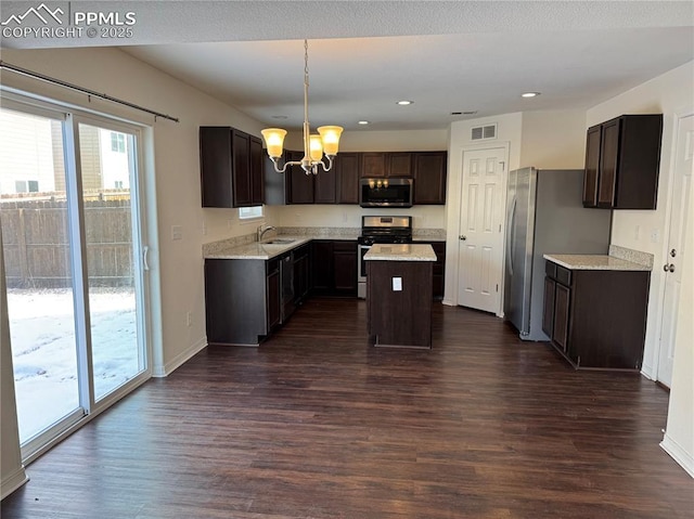 kitchen featuring stainless steel appliances, dark brown cabinets, dark wood finished floors, and visible vents