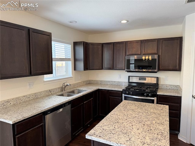 kitchen featuring appliances with stainless steel finishes, a sink, dark brown cabinetry, and recessed lighting