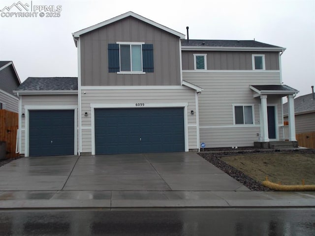 view of front of property with board and batten siding, driveway, and an attached garage