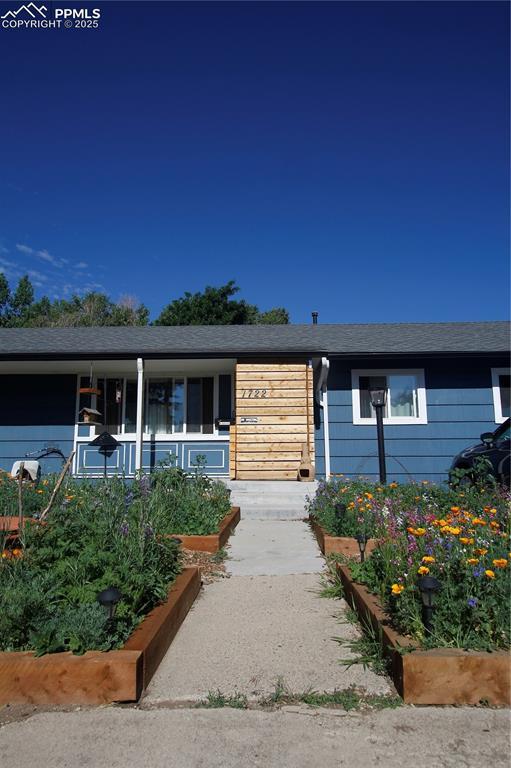 view of front of property featuring covered porch and a garden