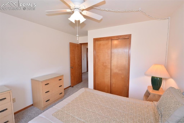 bedroom featuring baseboards, a closet, a ceiling fan, and light colored carpet