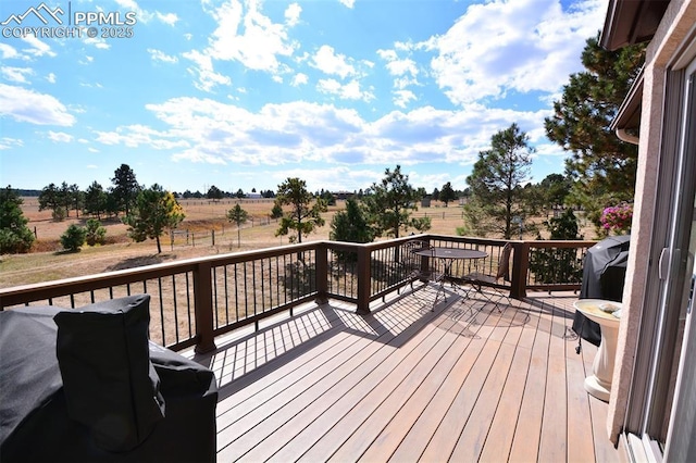 deck with area for grilling and a rural view