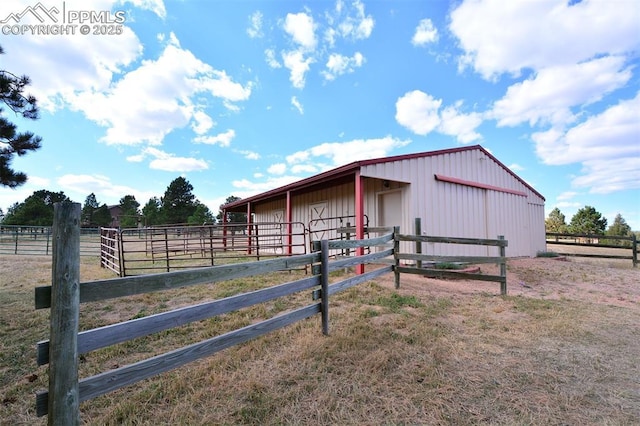 view of horse barn with a rural view