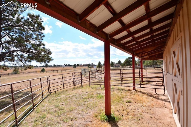 view of yard featuring an outbuilding, an exterior structure, and a rural view