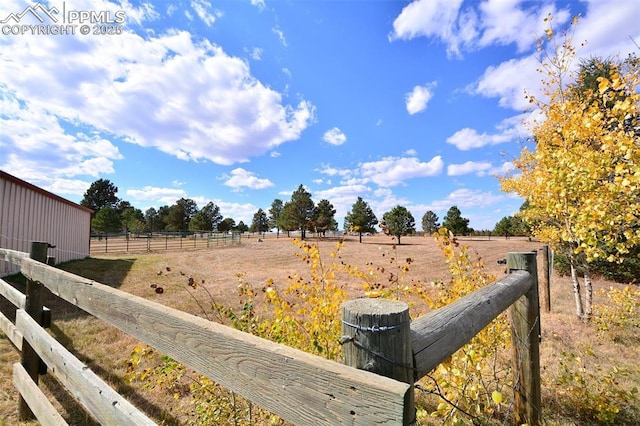 view of yard featuring fence and a rural view