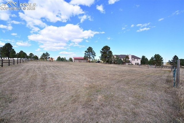 view of yard with a rural view and fence