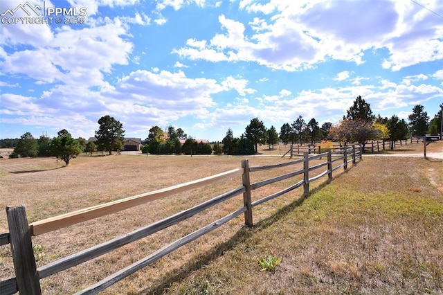 view of yard with fence and a rural view