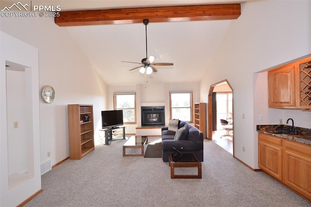 living room with beam ceiling, visible vents, light carpet, ceiling fan, and high vaulted ceiling