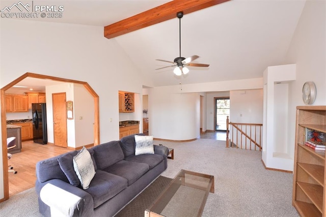 living area with light carpet, high vaulted ceiling, beam ceiling, and baseboards