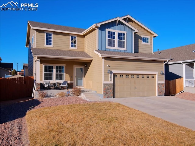 craftsman inspired home with driveway, an attached garage, covered porch, fence, and board and batten siding