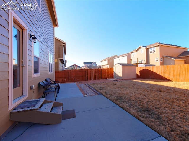 view of yard with a patio, a fenced backyard, a storage shed, an outdoor structure, and a residential view