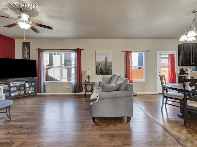 living room with a textured ceiling, dark wood-type flooring, and plenty of natural light