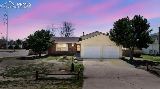 ranch-style home with concrete driveway, brick siding, and a garage