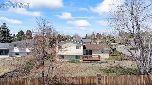 rear view of property with fence private yard and a deck