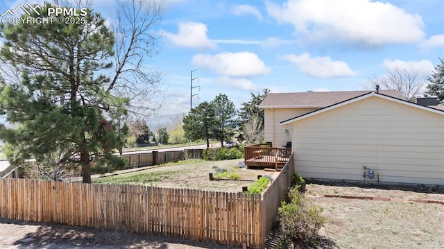 view of side of home with a fenced backyard and a wooden deck