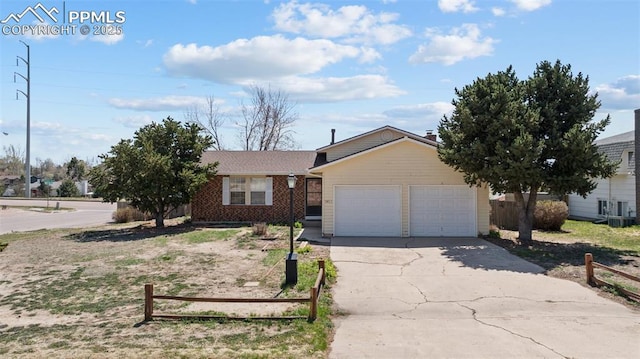 single story home with brick siding, a garage, fence, and driveway