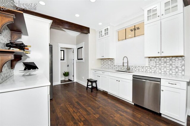 kitchen with a sink, light countertops, appliances with stainless steel finishes, decorative backsplash, and dark wood-style floors