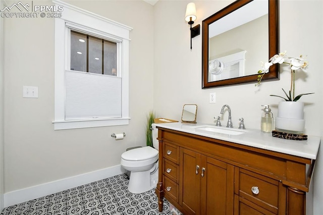 bathroom featuring toilet, tile patterned floors, baseboards, and vanity