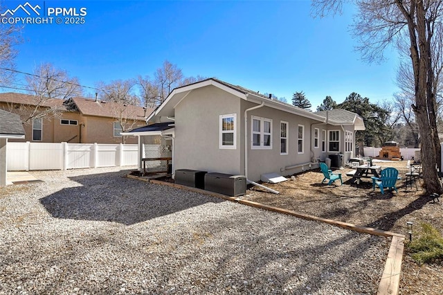 back of property featuring a patio area, fence, central AC unit, and stucco siding