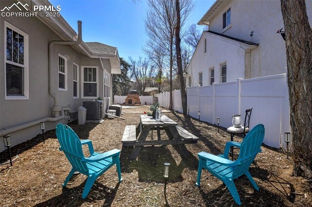 view of yard with central AC unit and fence