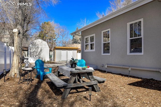 view of yard featuring an outbuilding, a shed, and fence