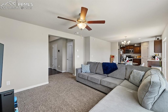 living area with carpet flooring, baseboards, and ceiling fan with notable chandelier