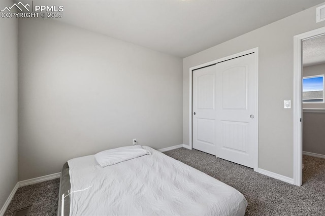 carpeted bedroom with a closet, visible vents, and baseboards