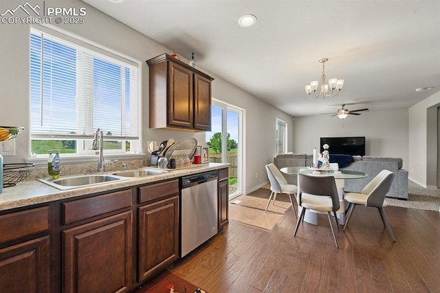 kitchen featuring dark wood finished floors, open floor plan, light countertops, stainless steel dishwasher, and a sink