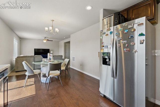 dining space featuring dark wood finished floors, baseboards, and ceiling fan with notable chandelier