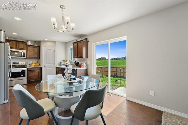 dining area featuring a chandelier, recessed lighting, dark wood finished floors, and baseboards