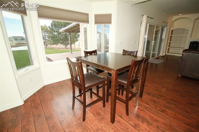 dining space with wood-type flooring and baseboards