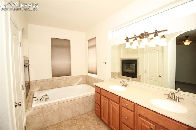 full bathroom featuring tile patterned flooring, double vanity, a sink, and a bath