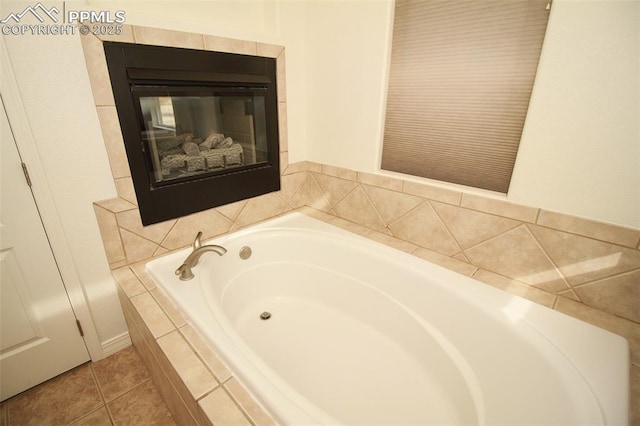 full bath with a tile fireplace, tile patterned floors, and a bath