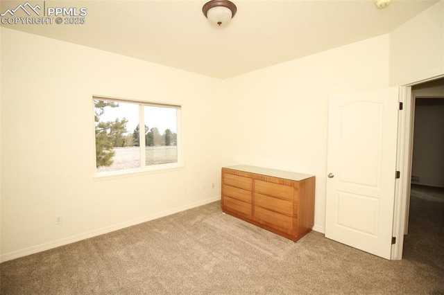 unfurnished room with baseboards and carpet flooring