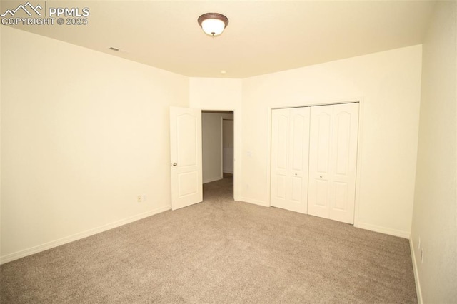 unfurnished bedroom featuring a closet, carpet flooring, and baseboards