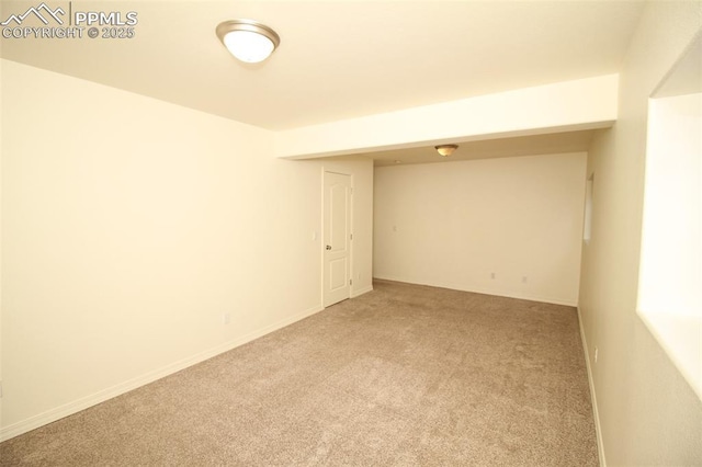 unfurnished room featuring baseboards and light colored carpet