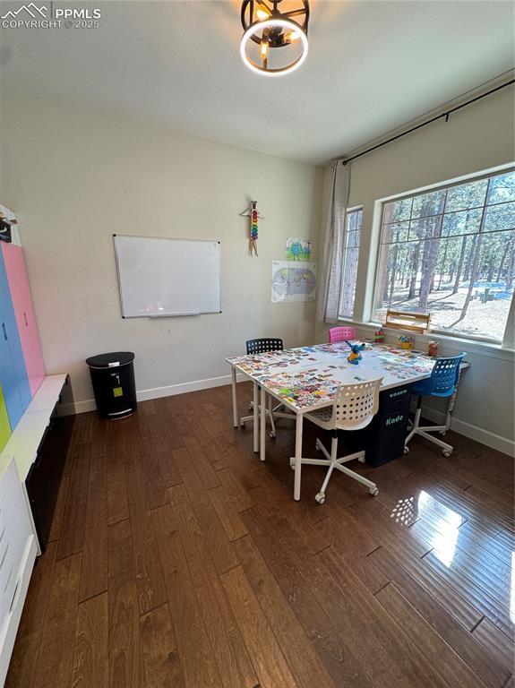 dining space featuring baseboards and dark wood-type flooring