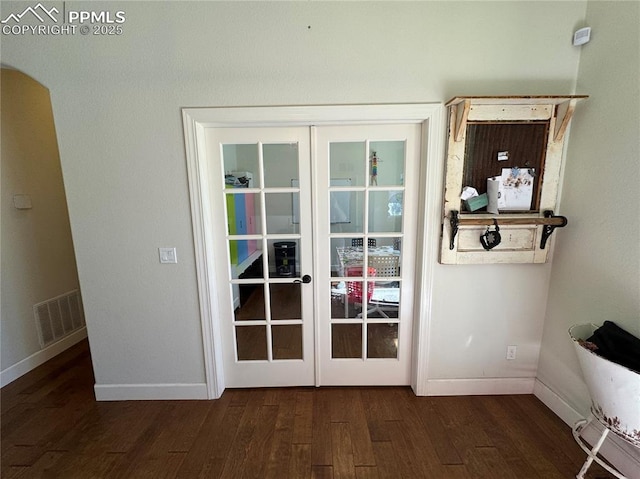 entryway with baseboards, visible vents, dark wood finished floors, arched walkways, and french doors