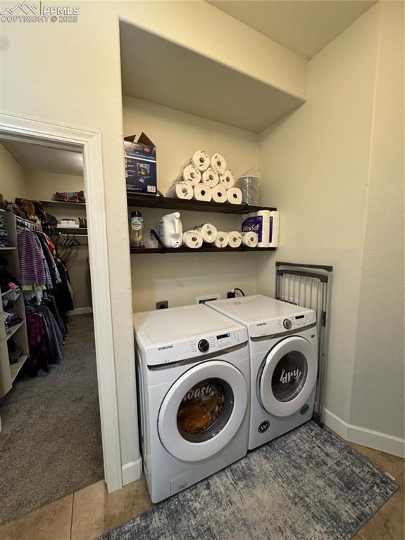 clothes washing area with dark colored carpet, laundry area, baseboards, and separate washer and dryer