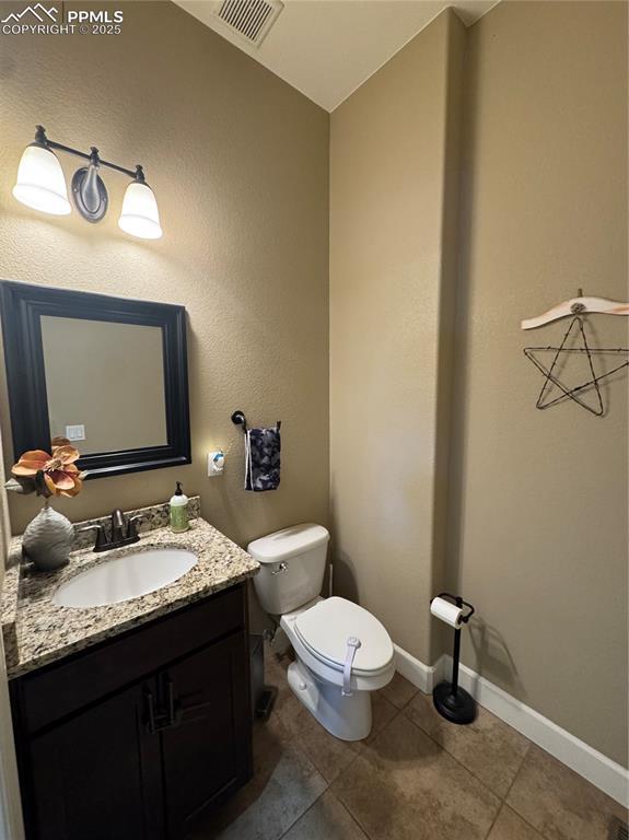 bathroom featuring visible vents, toilet, vanity, tile patterned flooring, and baseboards