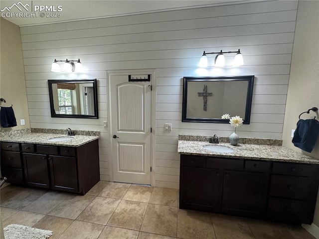 full bath featuring tile patterned flooring, two vanities, and a sink