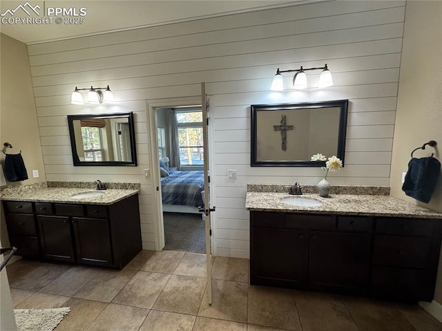 ensuite bathroom featuring two vanities, a sink, and ensuite bath