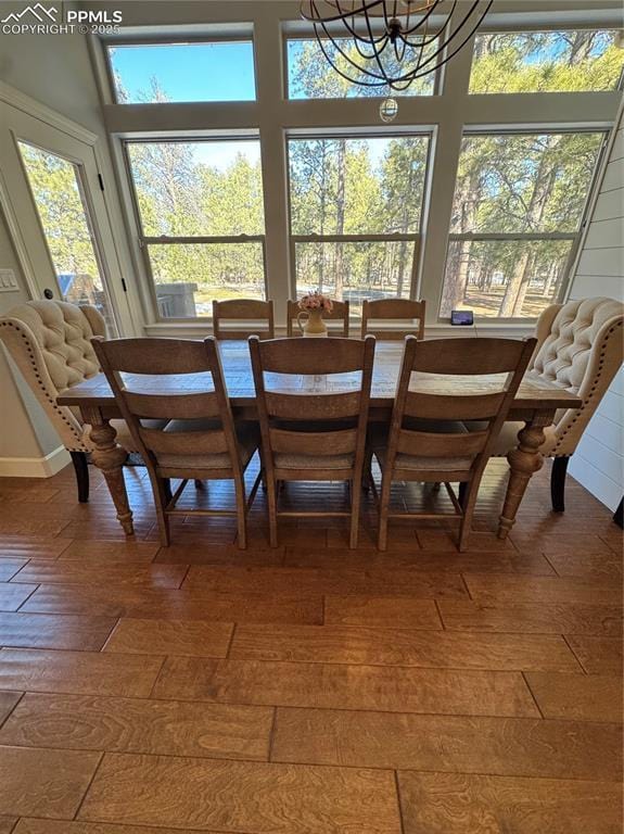 dining space featuring wood finished floors and an inviting chandelier