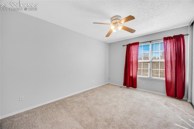 empty room with carpet flooring, ceiling fan, a textured ceiling, and baseboards