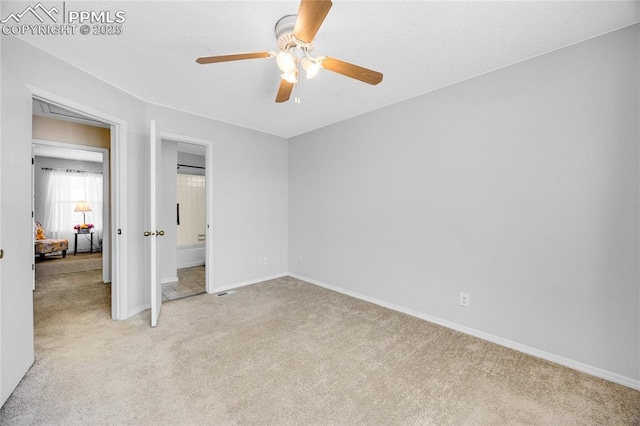 unfurnished bedroom featuring light carpet, visible vents, baseboards, a ceiling fan, and ensuite bath