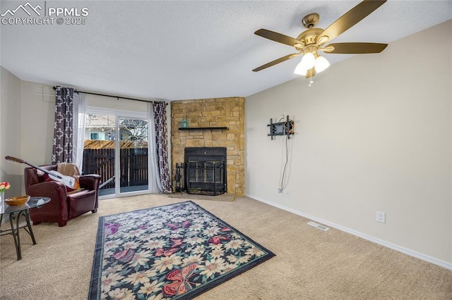 living room featuring baseboards, visible vents, a textured ceiling, a stone fireplace, and carpet floors